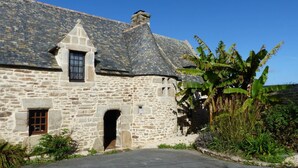 A stone building with a steeply pitched roof, a small window, and a doorway. - charming medieval house 3* (Baden)
