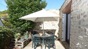 An outdoor patio with a table and chairs, a white umbrella, and potted plants. - charming medieval house 3* (Baden)