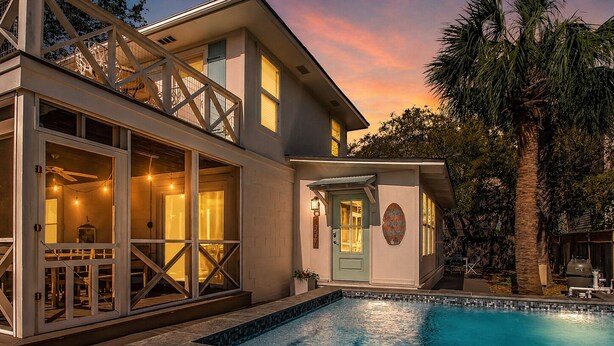 Une maison moderne dotée d’une piscine, d’une terrasse et d’une porte sur laquelle est apposée une plaque.