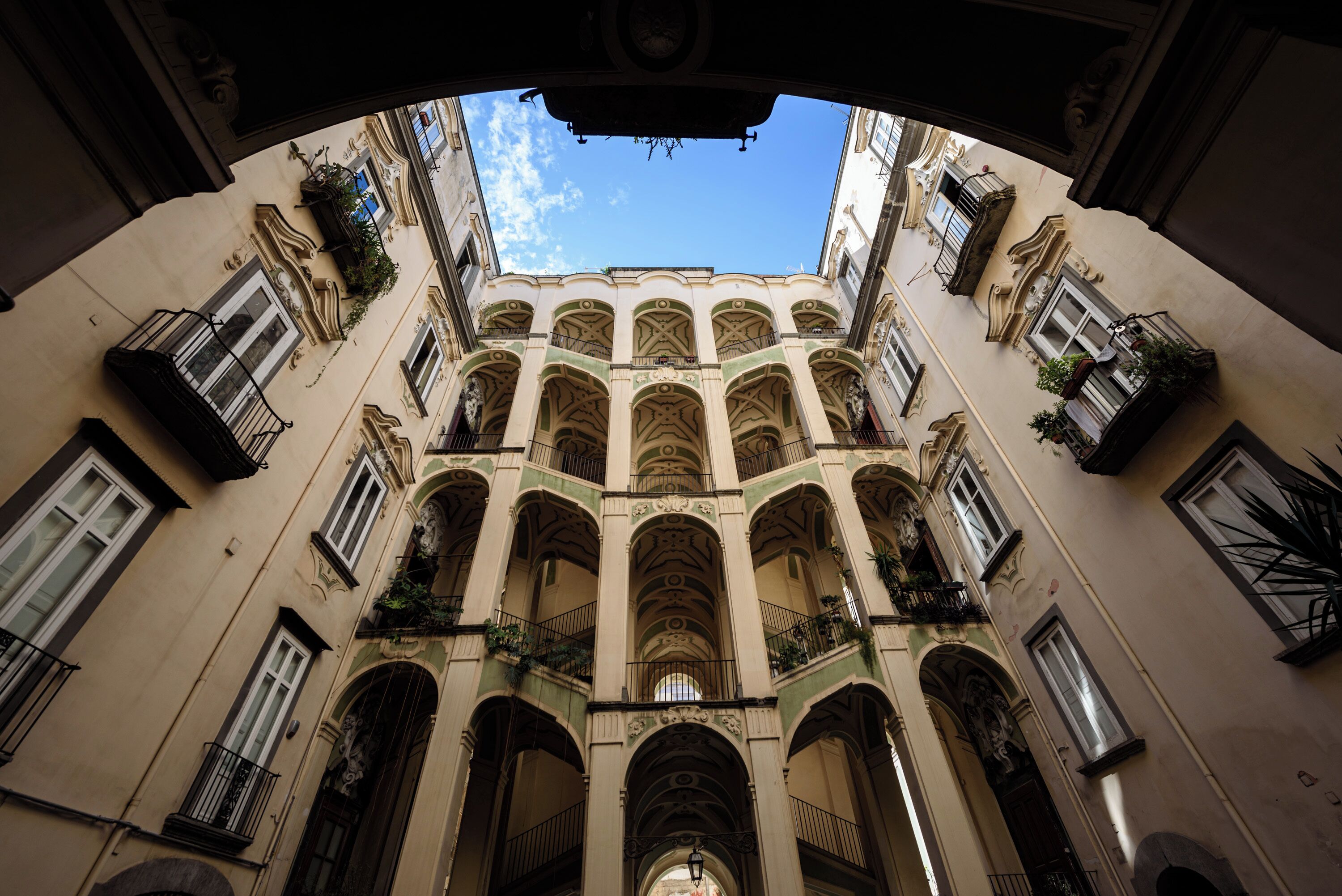 A view of a building's interior with multiple balconies and arches.
