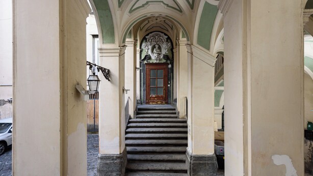Una escalera que lleva a una puerta con un arco decorativo.
