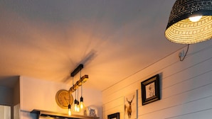 Un'accogliente zona pranzo con un tavolo in legno, panche e un lampadario.