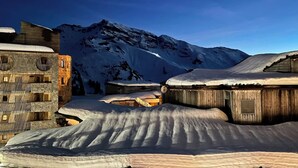 Un villaggio innevato con case di legno rustiche e una montagna sullo sfondo.