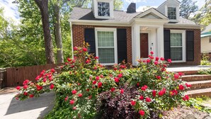A two-story house with a brick facade, white trim, and black shutters.