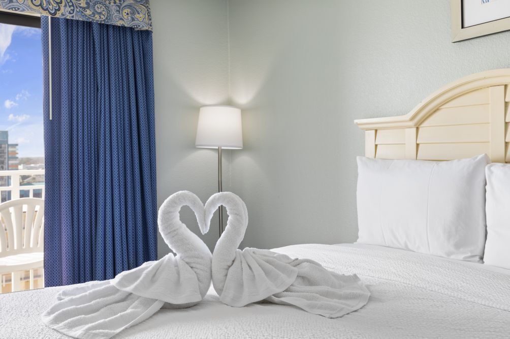 Une chambre d’hôtel avec un lit, une lampe et une vue sur la ville.