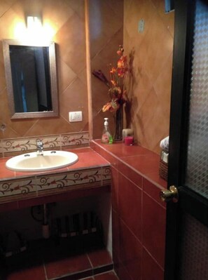 A bathroom with a sink, mirror, and decorative vase. - My Depa Mango In the Center of Cd. valleys (Ciudad Valles)