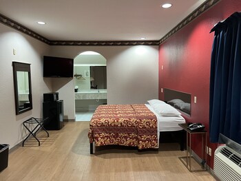 A hotel entrance with a check-in/out time sign, a notice about ID and photo requirements, and a window with a view of buildings outside. at Scott Inn Suites - Downtown Houston