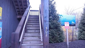 A wooden staircase leading to a building with a sign indicating 'Todd's' and 'White Side Realty'. - 4th Street Mkt Apt 302: Convenient Walk to Main Street | 2BR Apt in Highlands (Highlands)