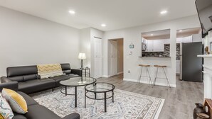 A modern living room with a black sofa, two glass tables, and a patterned rug. - One bedroom apartment in downtown Canandaigua (Canandaigua)
