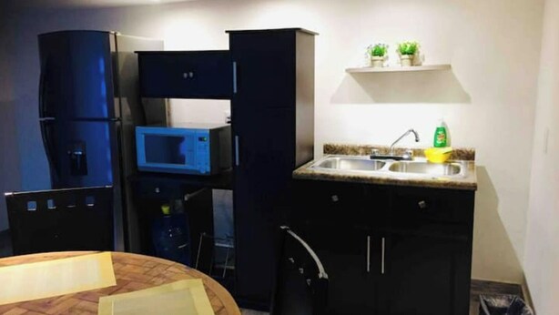 A compact kitchen with a microwave, sink, and cabinets. - My Depa Cinnamon In the Center of Cd. valleys (Ciudad Valles)