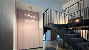A modern interior with a staircase, two armchairs, and a round table. - 11 Reyes Catolicos Premium Homes - Deluxe Homes (Alicante (Alacant))