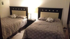 Two twin beds with matching headboards and footboards, a bedside table with a lamp, and a tiled floor. - My Depa Waterfall In the Center of Cd. valleys (Ciudad Valles)