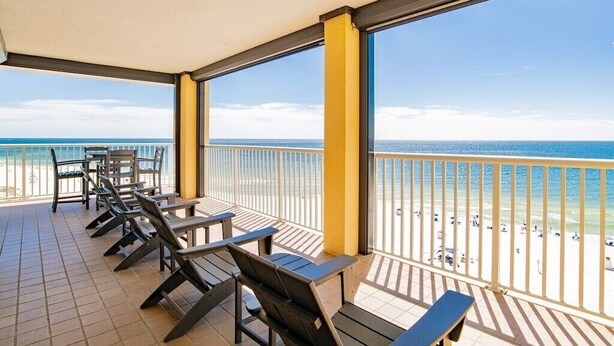 A balcony with sun loungers and a view of the beach.