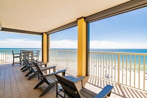 Un balcón con sillones de sol y vista a la playa.