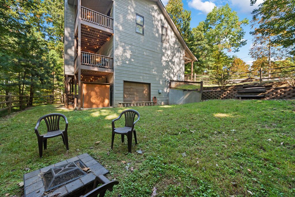 A two-story house with a deck and a fire pit in the backyard.