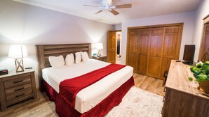 A bedroom with a bed, wooden headboard, bedside tables, a nightstand, a ceiling fan, a wardrobe, and a desk with a plant. - 1BR Cascade Village condo with pool, hot tub, fireplace, and full kitchen. (Durango)