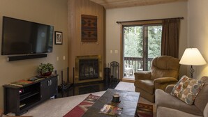 A living room with a fireplace, a television, and a sofa. - Two Bedroom - Cascade Village condo with mountain views, pool, hot tub, and ski access (Durango)