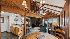 Una cocina amplia con armarios de madera, un comedor con una mesa redonda y una chimenea.