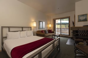 Relax in a spacious room with a large bed, sofa, and balcony offering a view of the outdoors.