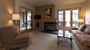 Ein Wohnzimmer mit Kamin, Fernseher und einer Couch.