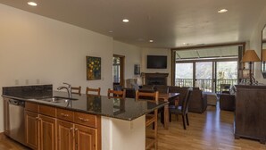 Una cocina amplia con una isla grande, armarios de madera y un comedor con chimenea.