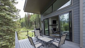 A deck with a table and chairs, a grill, and a fireplace. - Tacoma Vista 147 - Managed by Purgatory Result (Durango)