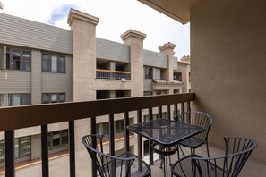 Enjoy dining or socializing on this balcony with a set of four chairs and a table.
