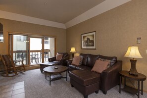 Relax in a comfortable seating area with a large sofa, matching ottomans, and a coffee table.