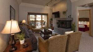 Ein Wohnzimmer mit Kamin, Sofas, Couchtisch und Fernseher.