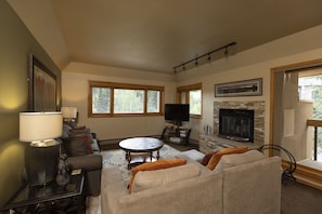 A living room with a fireplace, a television, and a sofa.