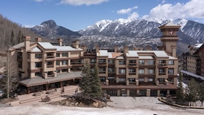 Un hôtel à plusieurs étages doté d’une cour intérieure, entouré de montagnes.
