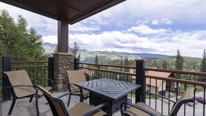A balcony with outdoor furniture, a stone pillar, and a view of mountains and trees. - Purgatory Lodge 201 - Managed by Purgatory 201 (Durango)