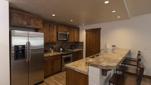 Una cocina moderna con armarios de madera, electrodomésticos de acero inoxidable y encimera de granito.