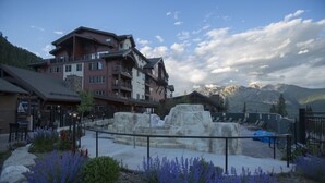 A multi-story hotel with a stone facade, outdoor seating area, and a view of mountains. - Purgatory Lodge 204 - Managed by Purgatory Resort (Durango)