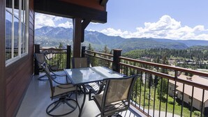 Ein Balkon mit Tisch und Stühlen mit Blick auf eine Berglandschaft.