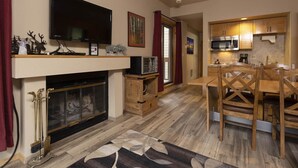 Une cuisine moderne avec des meubles en bois, un four à micro-ondes encastré et un coin repas comprenant une table et des chaises en bois.