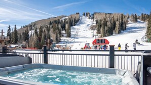 A hot tub with a view of a ski slope and a red bus in the background. - Purgatory Lodge 101 -  Managed by Purgatory Resort (Durango)