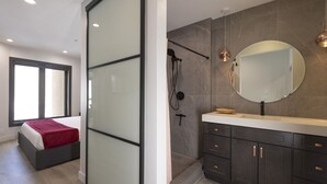 Un dormitorio moderno con una cama, una puerta corredera y un ventanal grande.