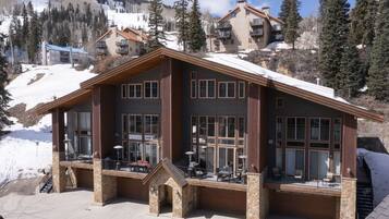 A large lodge with multiple balconies, large windows, and a stone facade.