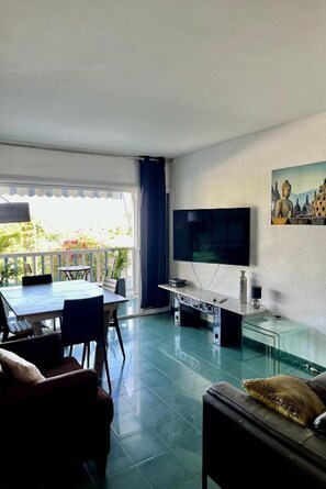 Un salon moderne doté d’un téléviseur, de sièges et d’un balcon.
