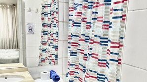 Een badkamer met toilet, wastafel en spiegel.