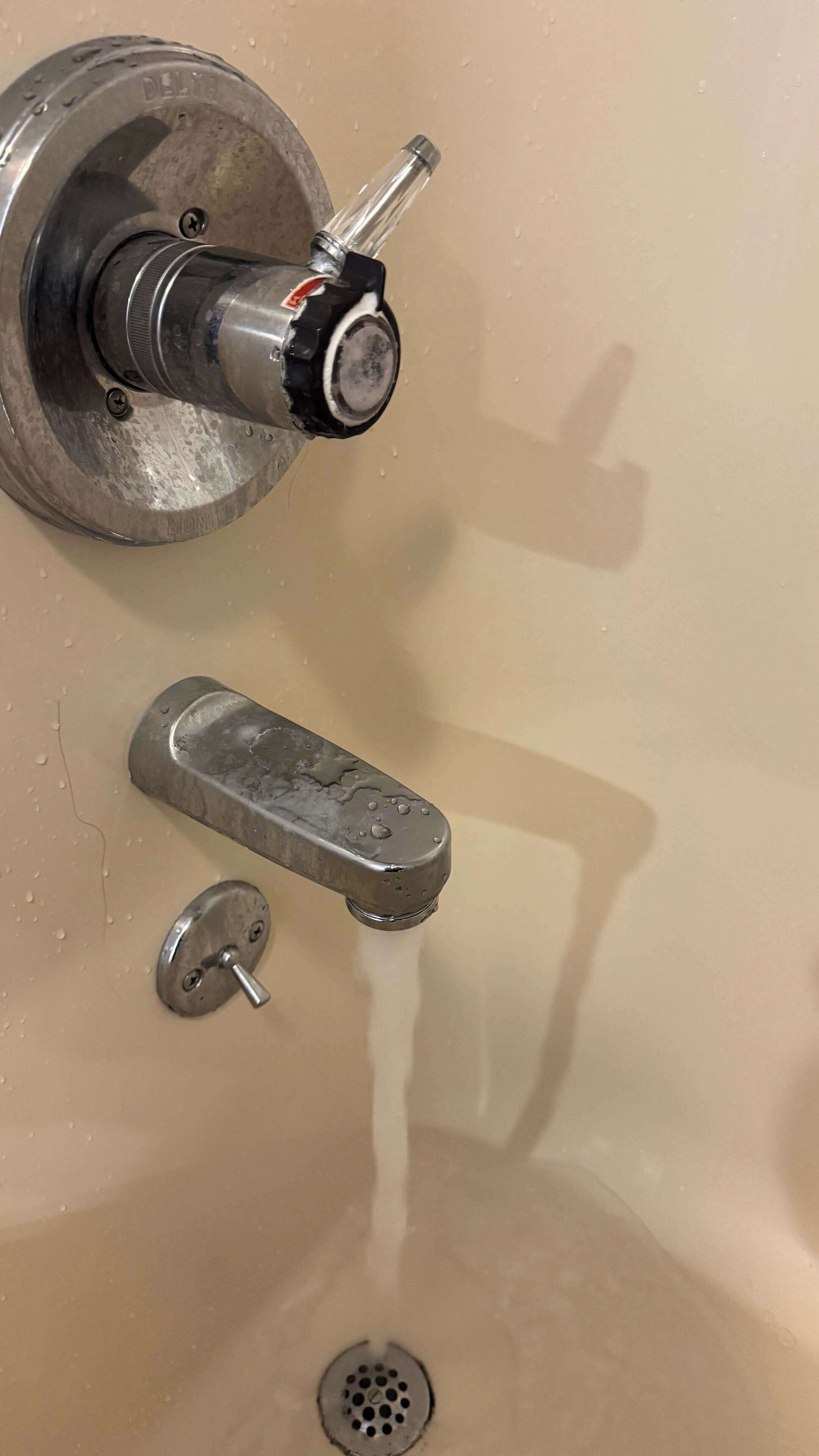 A bathroom sink with a faucet, a mirror, and a drain.