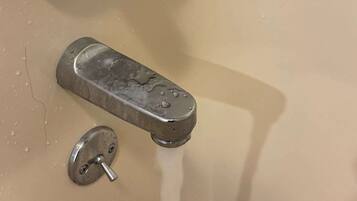 A bathroom sink with a faucet, a mirror, and a drain.