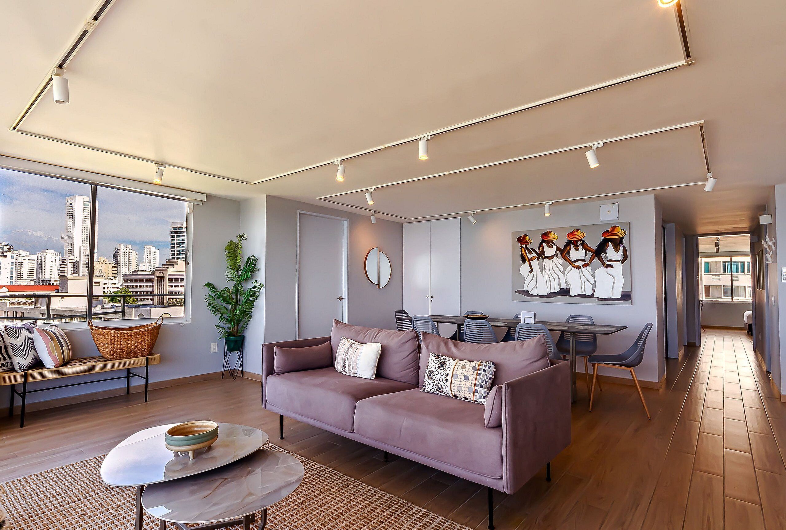 A modern living room with a sofa, coffee table, and dining area.