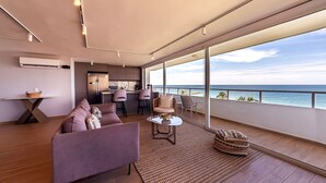 A modern interior with a sofa, dining area, and a view of the sea. - U-GO Faro Tequendema (Cartagena)