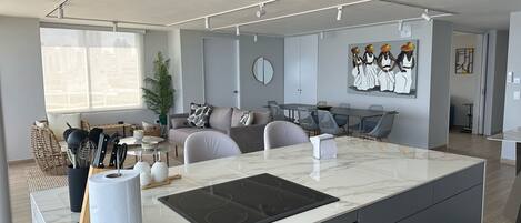 A modern kitchen with a central island, built-in appliances, and a dining area with a large table.