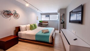 A modern hotel room with a bed, a desk, a TV, and a bicycle art piece. - U-GO Faro Tequendema (Cartagena)