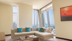 A modern living room with a sectional sofa, a glass coffee table, and large windows offering a city view. - Le Méridien City Center, Doha (Doha)