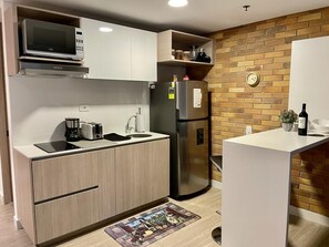 Microondas, cafetera y tetera, utensilios de cocina y toallas de papel 