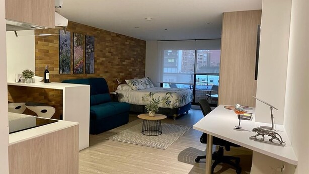 A modern apartment with a living area, a kitchen, and a bedroom.
